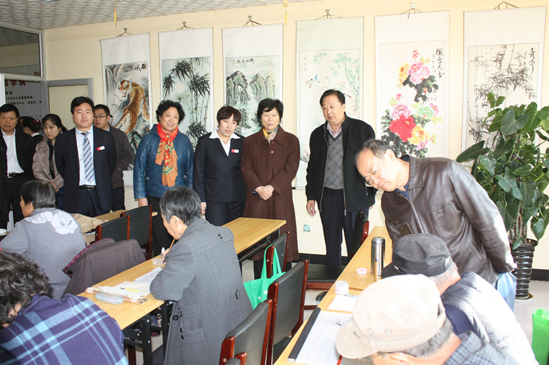 在卓達(dá)物業(yè)星辰花園視察社區(qū)養(yǎng)老工作的領(lǐng)導(dǎo)們，在觀看老年大學(xué)的書法學(xué)習(xí)班。